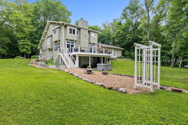 10390 Fenner Ave SE, Franklin Twp, MN 55328 - rear view of house featuring a chimney, a deck, a hot tub, stairway, and a yard