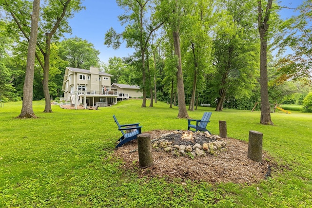 10390 Fenner Ave SE, Franklin Twp, MN 55328 - view of grassy yard with a fire pit and view of scattered trees