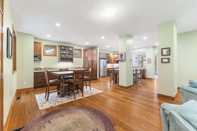 10390 Fenner Ave SE, Franklin Twp, MN 55328 - dining area with bar with sink, light wood-style flooring, baseboards, and recessed lighting