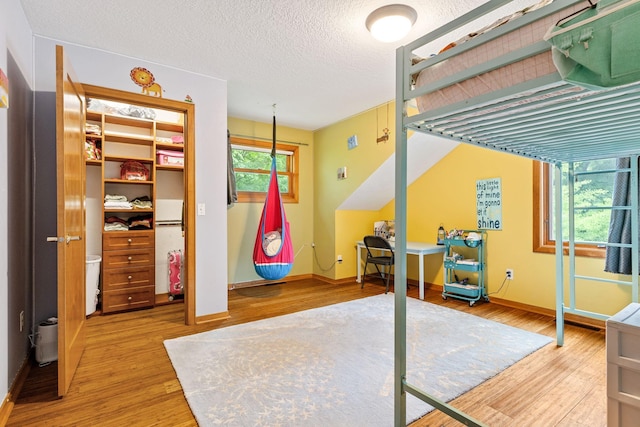 10390 Fenner Ave SE, Franklin Twp, MN 55328 - bedroom with wood finished floors, baseboards, a textured ceiling, and a closet