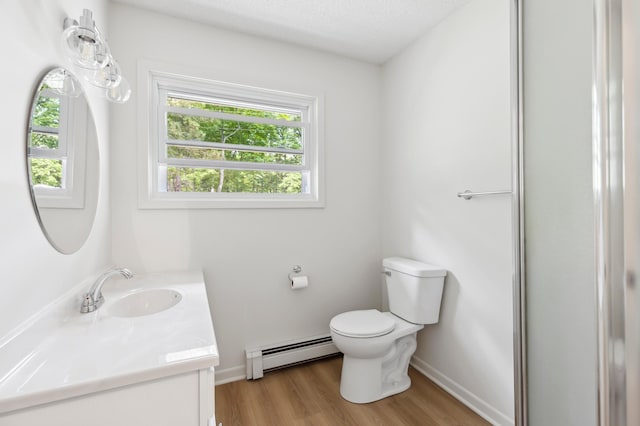8996 Little Pelican Dr, Pelican Twp, MN 56472 - bathroom featuring a baseboard heating unit, toilet, vanity, wood finished floors, and baseboards