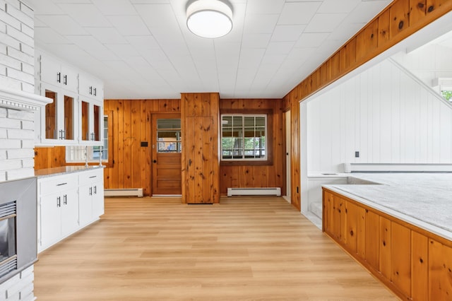 8996 Little Pelican Dr, Pelican Twp, MN 56472 - kitchen with a baseboard heating unit, light countertops, light wood-style floors, and wood walls