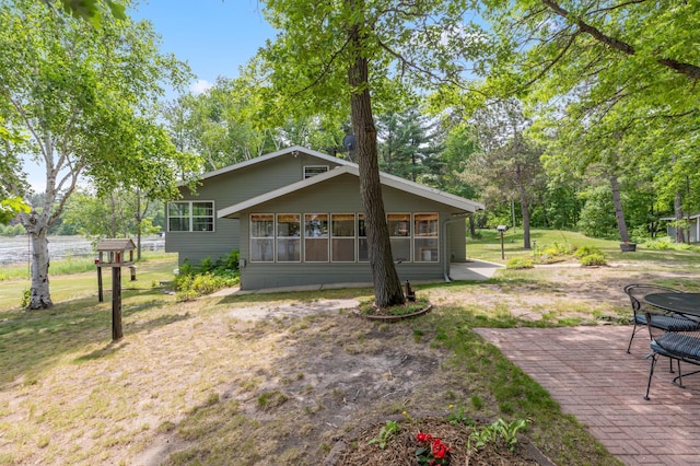 8996 Little Pelican Dr, Pelican Twp, MN 56472 - rear view of property featuring a lawn, a patio, a sunroom, and view of wooded area