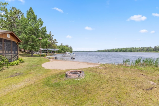 8996 Little Pelican Dr, Pelican Twp, MN 56472 - view of green lawn featuring a fire pit, a water view, and a sunroom