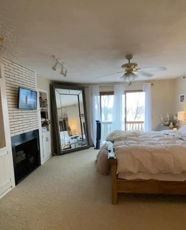 606 Swain St, Redwood Falls, MN 56283 - bedroom featuring a brick fireplace, light colored carpet, a ceiling fan, and track lighting