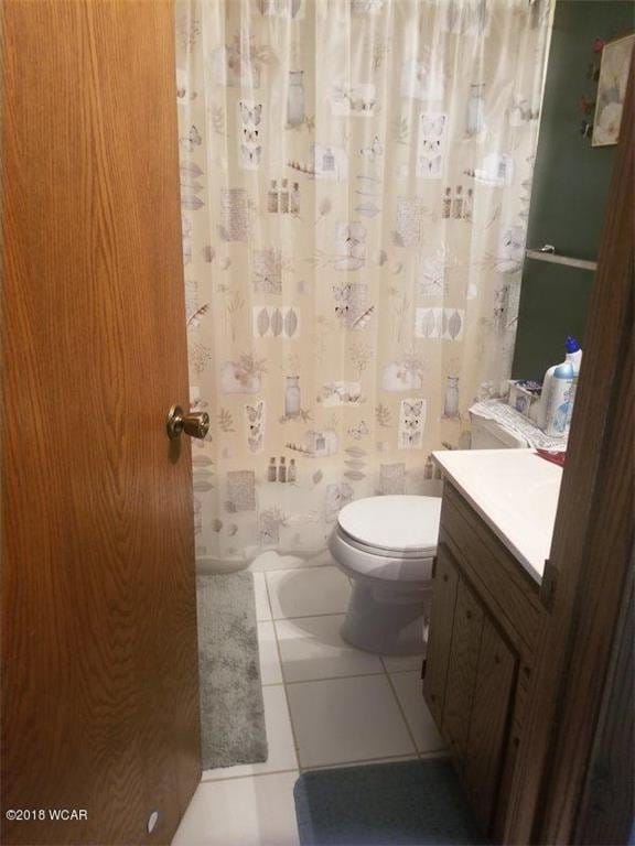 606 Swain St, Redwood Falls, MN 56283 - bathroom with tile patterned floors, vanity, a shower with shower curtain, and toilet