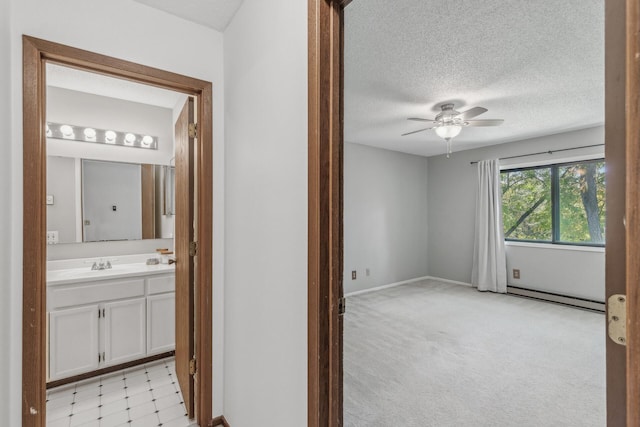 400 Shelard Pkwy Unit 303, Saint Louis Park, MN 55426 - bathroom with a baseboard radiator, a ceiling fan, vanity, a textured ceiling, and baseboards