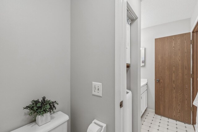 400 Shelard Pkwy Unit 303, Saint Louis Park, MN 55426 - half bathroom with vanity, tile patterned floors, toilet, and washer / dryer