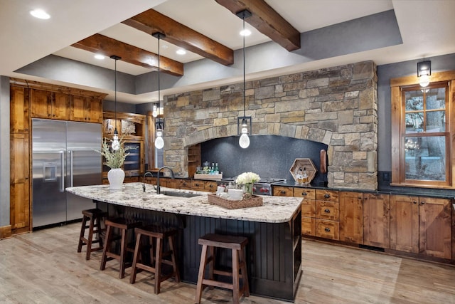 9328 Rhoy Ave, Chaska, MN 55318 - kitchen with stainless steel built in fridge, a sink, light wood-type flooring, light stone countertops, and beamed ceiling