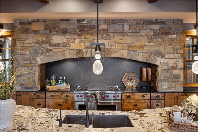 9328 Rhoy Ave, Chaska, MN 55318 - kitchen with brown cabinetry, high end stove, light stone counters, and a sink