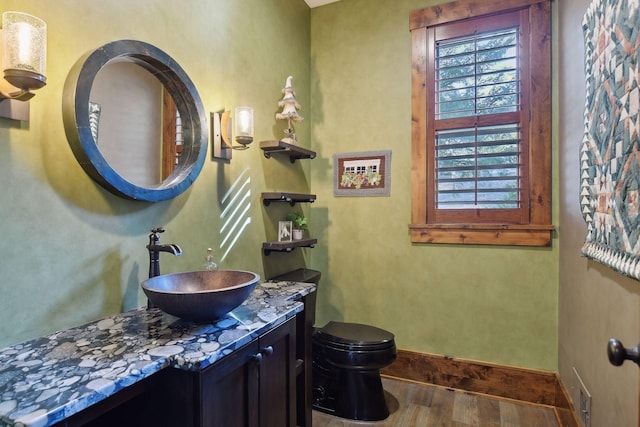 9328 Rhoy Ave, Chaska, MN 55318 - half bathroom with wood finished floors, baseboards, toilet, and vanity