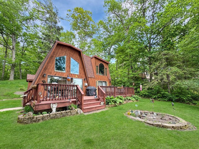 256 22 5/8 Ave, Crystal Lake Twp, WI 54829 - rear view of house featuring a lawn, a wooden deck, a gambrel roof, and roof with shingles