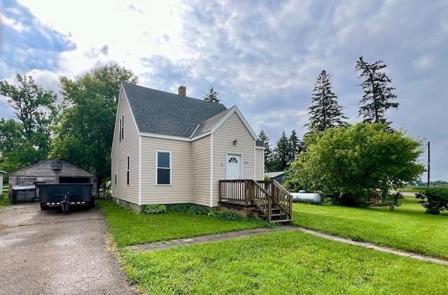 406 1st St S, Hoffman, MN 56339 - view of front of property featuring an outbuilding, a shingled roof, a front yard, a chimney, and a garage