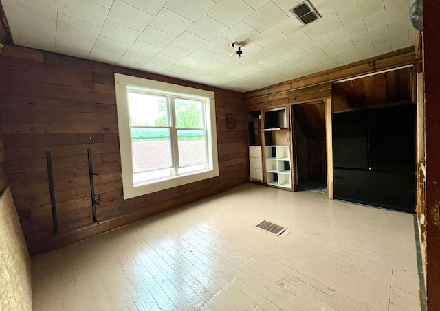 406 1st St S, Hoffman, MN 56339 - unfurnished bedroom featuring wooden walls and light wood-type flooring