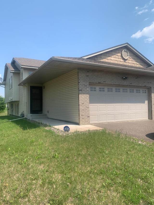 922 Whiskey Rd NW, Isanti, MN 55040 - view of home's exterior with brick siding, a lawn, a garage, and driveway