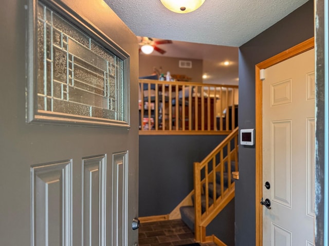 922 Whiskey Rd NW, Isanti, MN 55040 - entrance foyer with a ceiling fan, stairway, a textured ceiling, brick patterned floors, and baseboards