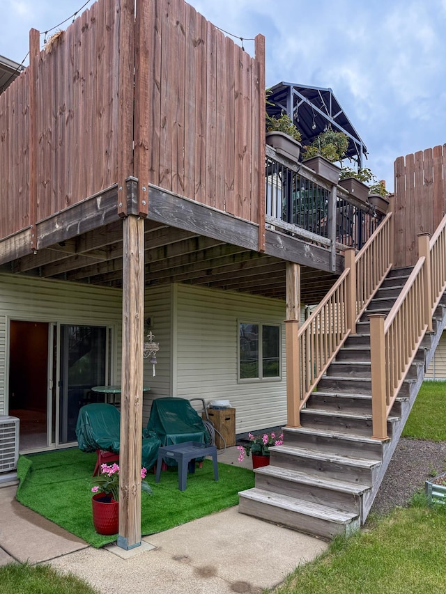 922 Whiskey Rd NW, Isanti, MN 55040 - back of property with a deck, stairway, and a lawn