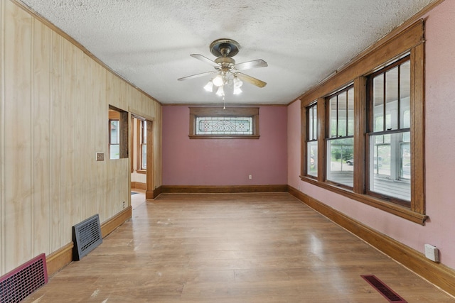 363 Geranium Ave E, Saint Paul, MN 55130 - unfurnished room featuring ornamental molding, light wood-type flooring, ceiling fan, a textured ceiling, and healthy amount of natural light