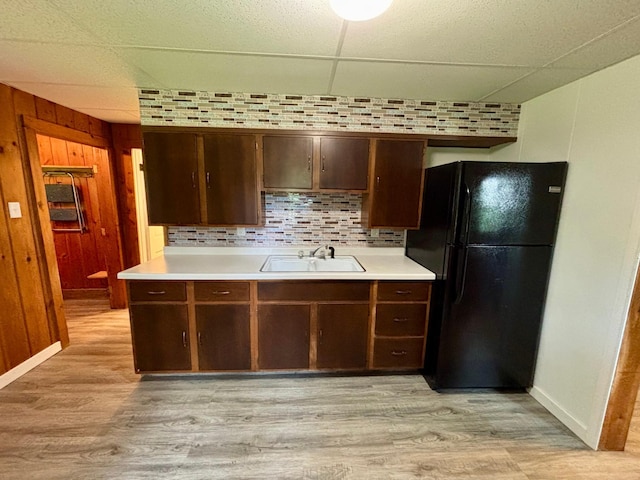 1116 Whitford St, Fergus Falls, MN 56537 - kitchen featuring freestanding refrigerator, light wood-type flooring, light countertops, tasteful backsplash, and dark brown cabinets