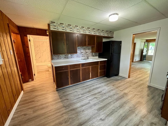 1116 Whitford St, Fergus Falls, MN 56537 - kitchen featuring freestanding refrigerator, light wood-style floors, light countertops, a paneled ceiling, and wooden walls