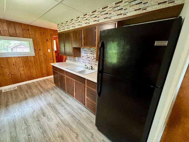 1116 Whitford St, Fergus Falls, MN 56537 - kitchen with freestanding refrigerator, light countertops, light wood-style flooring, tasteful backsplash, and a drop ceiling