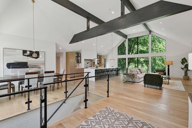 6608 Pawnee Rd, Edina, MN 55439 - living room featuring high vaulted ceiling, beamed ceiling, a chandelier, and light wood-style flooring