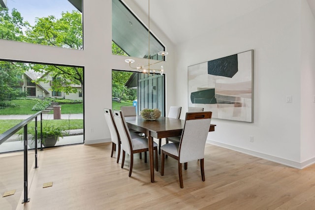 6608 Pawnee Rd, Edina, MN 55439 - dining space featuring wood finished floors, a chandelier, and a towering ceiling