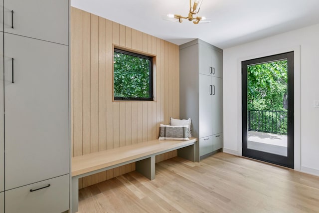 6608 Pawnee Rd, Edina, MN 55439 - mudroom featuring wooden walls, light wood-style floors, and a chandelier