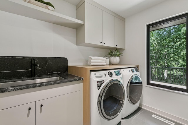 6608 Pawnee Rd, Edina, MN 55439 - washroom with separate washer and dryer, cabinet space, and tile patterned floors
