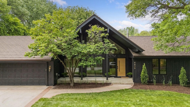 6608 Pawnee Rd, Edina, MN 55439 - view of front of house with board and batten siding, driveway, a front lawn, an attached garage, and a tile roof