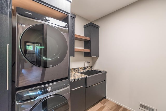 19923 See Gull Rd, Brainerd, MN 56401 - washroom featuring stacked washer / drying machine, light wood-type flooring, cabinet space, and baseboards