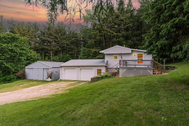 W7324 State Road 65, Trimbelle, WI 54003 - view of front of house featuring driveway, a front yard, a wooden deck, an outbuilding, and a garage