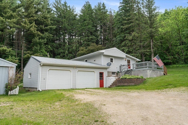 W7324 State Road 65, Trimbelle, WI 54003 - view of side of home with driveway, a deck, stairway, a lawn, and an attached garage