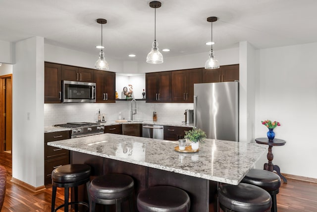 5605 Donegal Dr, Shoreview, MN 55126 - kitchen featuring appliances with stainless steel finishes, dark wood-style floors, a sink, dark brown cabinetry, and backsplash