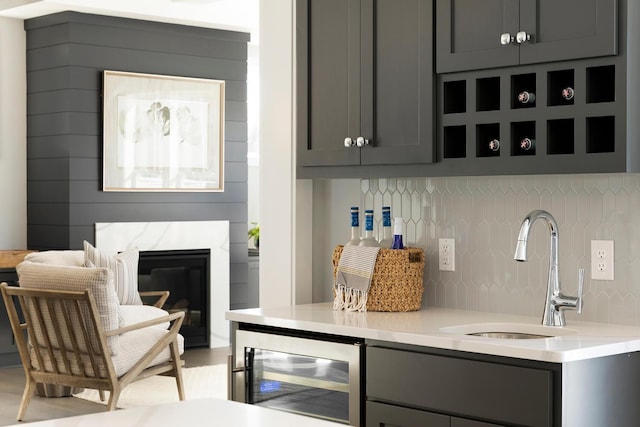 6501 Timber Arch Dr, Chaska, MN 55318 - bar with beverage cooler, a sink, backsplash, and a fireplace