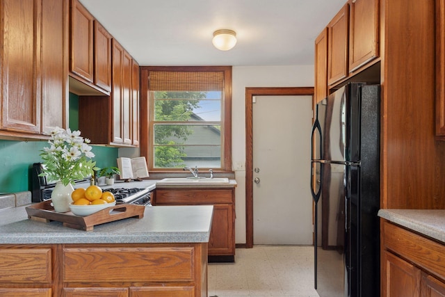 3015 22nd St, Minneapolis, MN 55406 - kitchen with freestanding refrigerator, light floors, brown cabinets, and light countertops