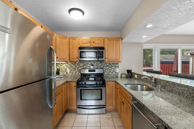 2800 Alabama Ave S, Saint Louis Park, MN 55416 - kitchen with stainless steel appliances, a sink, a textured ceiling, decorative backsplash, and dark stone countertops
