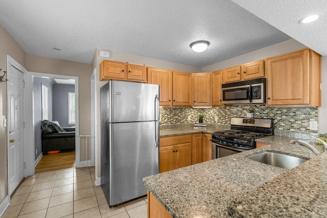 2800 Alabama Ave S, Saint Louis Park, MN 55416 - kitchen with appliances with stainless steel finishes, a sink, a textured ceiling, dark stone counters, and light tile patterned flooring