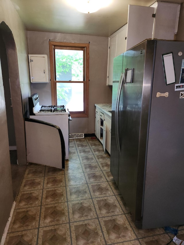 1816 Malvern St, Lauderdale, MN 55113 - kitchen featuring freestanding refrigerator, gas range gas stove, white cabinetry, light countertops, and tile patterned floors