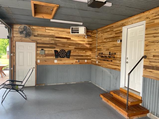 409 Iris Ln NE, Saint Joseph, MN 56374 - garage with wooden walls and a garage door opener