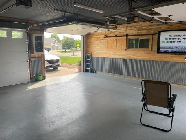 409 Iris Ln NE, Saint Joseph, MN 56374 - garage featuring wooden walls and a garage door opener