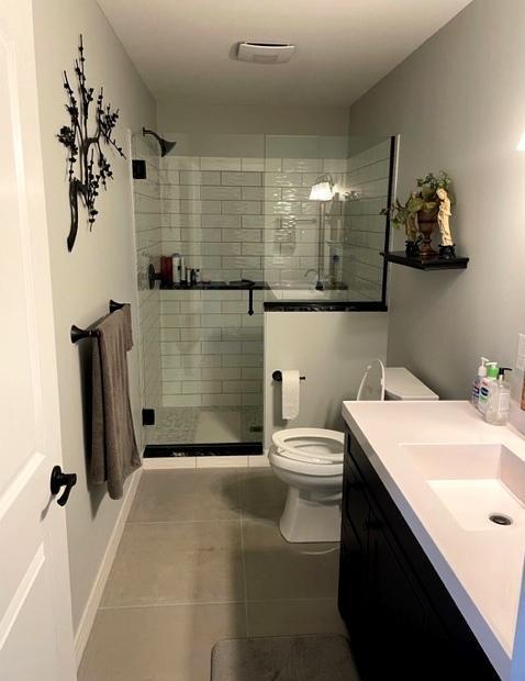 409 Iris Ln NE, Saint Joseph, MN 56374 - full bathroom featuring tile patterned flooring, toilet, vanity, and a shower stall