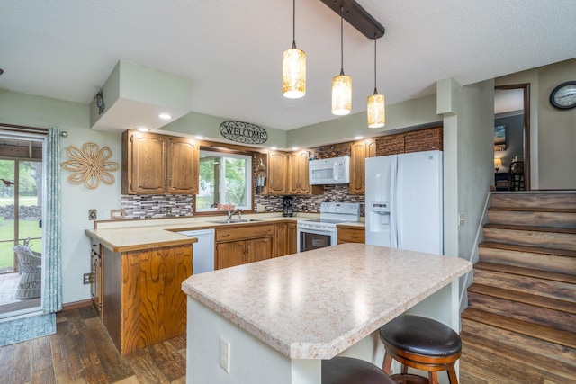 701 Mill St, Fertile, MN 56540 - kitchen featuring white appliances, a sink, dark wood-style flooring, light countertops, and decorative backsplash