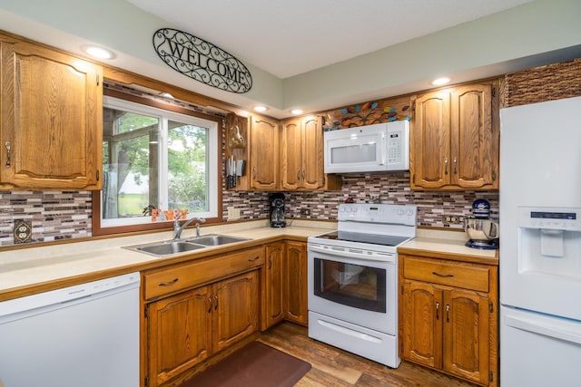 701 Mill St, Fertile, MN 56540 - kitchen featuring white appliances, a sink, light countertops, backsplash, and dark wood-style floors