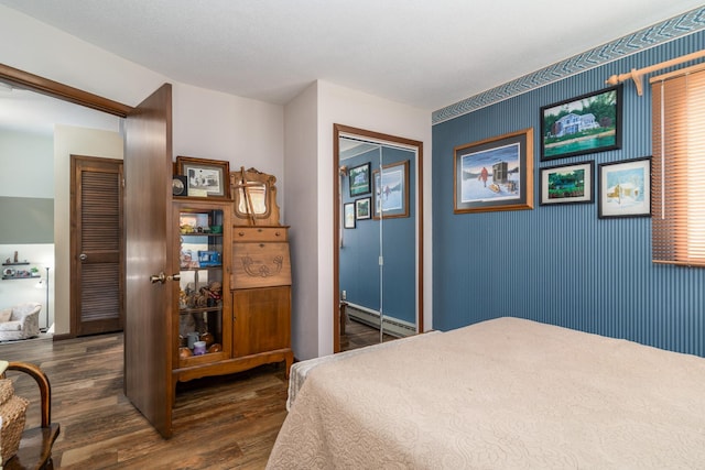 701 Mill St, Fertile, MN 56540 - bedroom featuring wood finished floors, a baseboard radiator, a closet, and baseboards