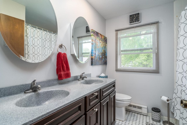 701 Mill St, Fertile, MN 56540 - bathroom featuring baseboard heating, toilet, double vanity, and tile patterned floors