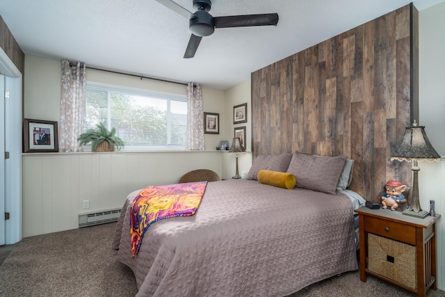 701 Mill St, Fertile, MN 56540 - carpeted bedroom featuring baseboard heating, wood walls, ceiling fan, and a wainscoted wall