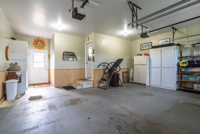 701 Mill St, Fertile, MN 56540 - garage with freestanding refrigerator, a wainscoted wall, a garage door opener, and wood walls