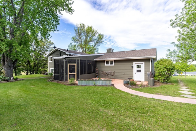 701 Mill St, Fertile, MN 56540 - back of property featuring a sunroom, a lawn, and a patio
