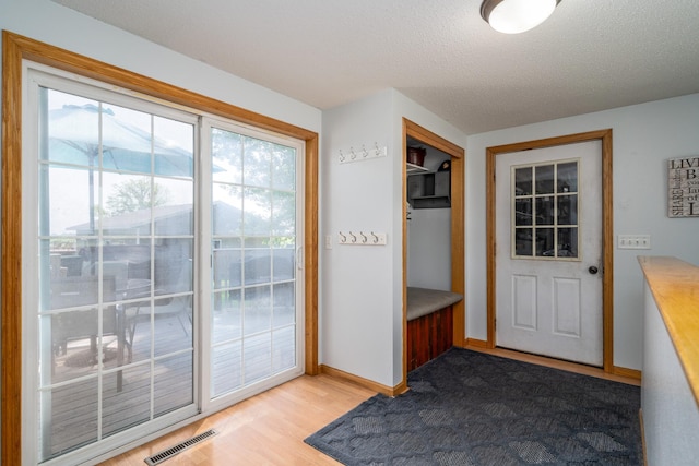 501 Thompson Ave, Fisher, MN 56723 - doorway with baseboards, light wood-style flooring, and a textured ceiling